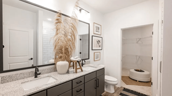 A bathroom with a white sink and a white toilet.